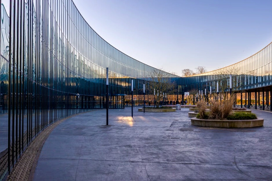 Moderní univerzitní budova s prosklenou fasádou.